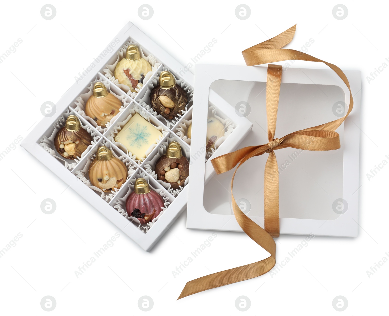 Photo of Open box with delicious chocolate in shape of Christmas ornaments isolated on white, top view