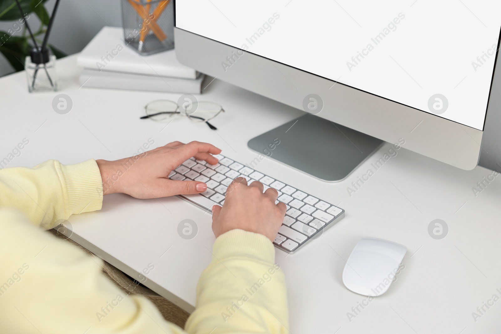 Photo of Woman working on computer at desk indoors, closeup