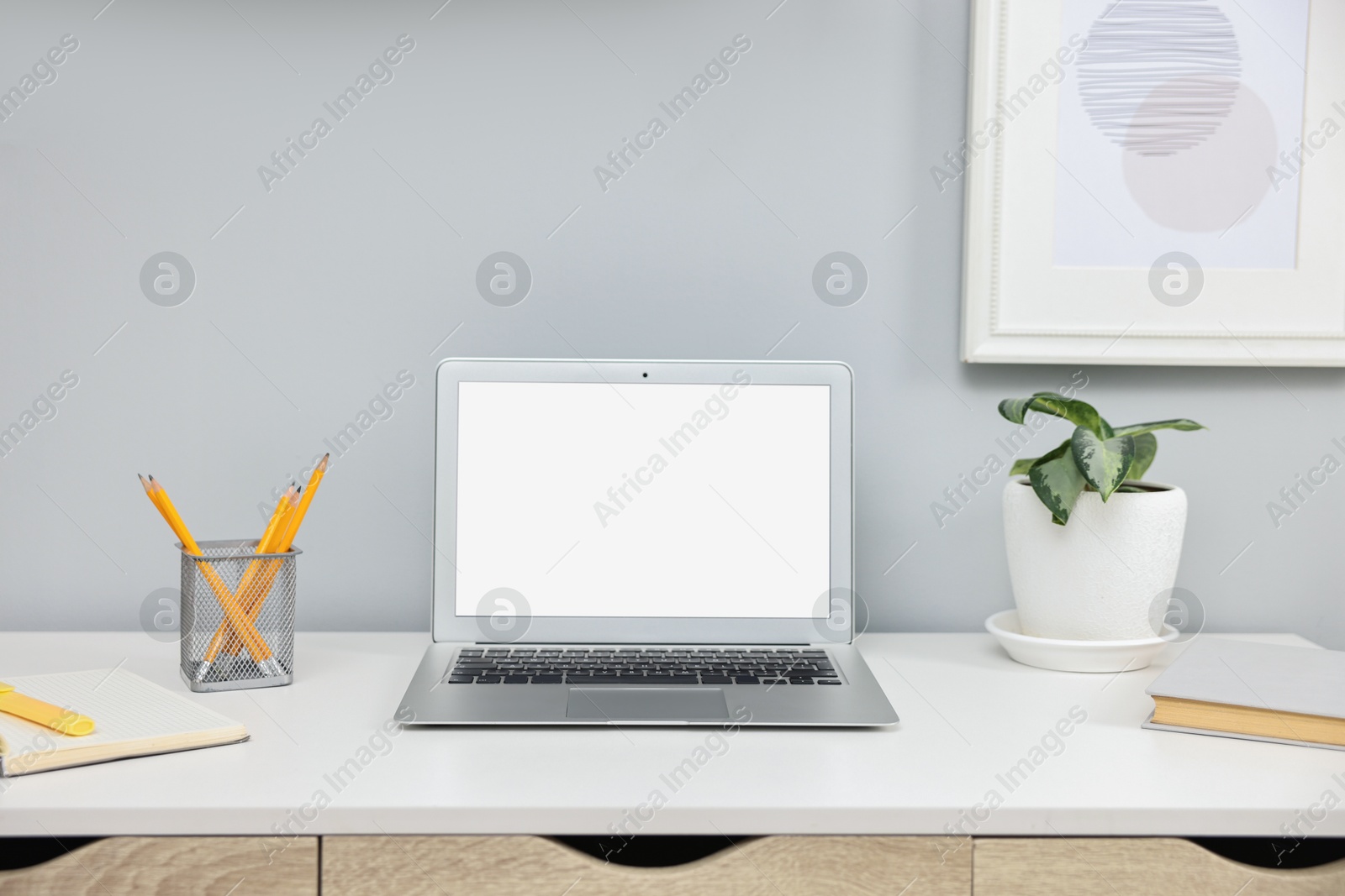 Photo of Comfortable workplace with modern laptop on white table indoors