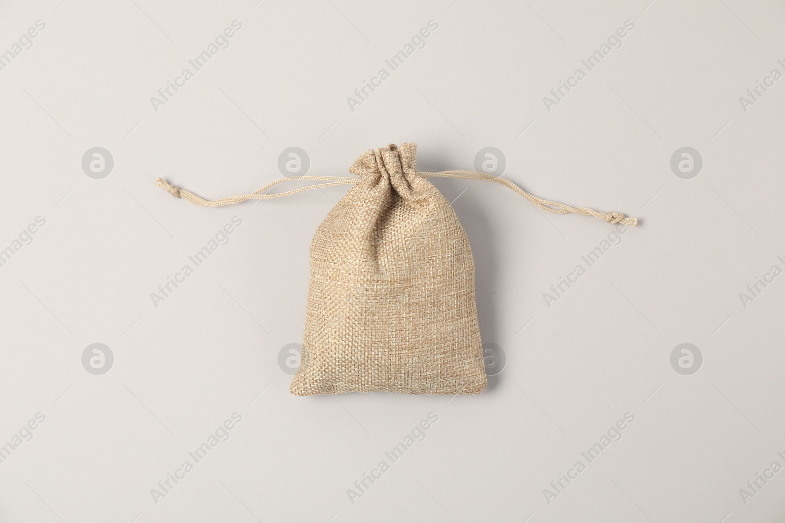 Photo of One burlap bag on light background, top view