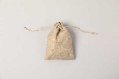 Photo of One burlap bag on light background, top view