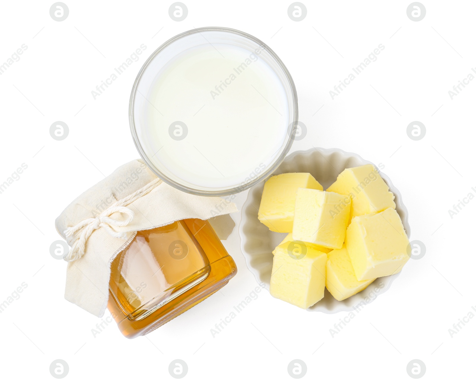 Photo of Jar of honey, milk in glass and butter isolated on white, top view