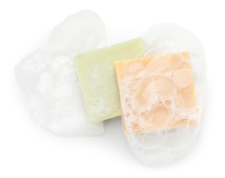 Photo of Soap bars with foam on white background, top view