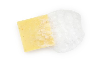 Photo of Yellow soap with foam on white background, top view