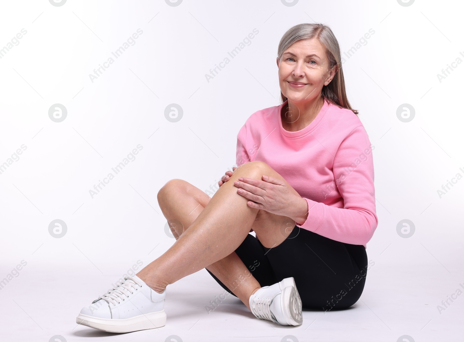 Photo of Senior woman suffering from knee pain on white background