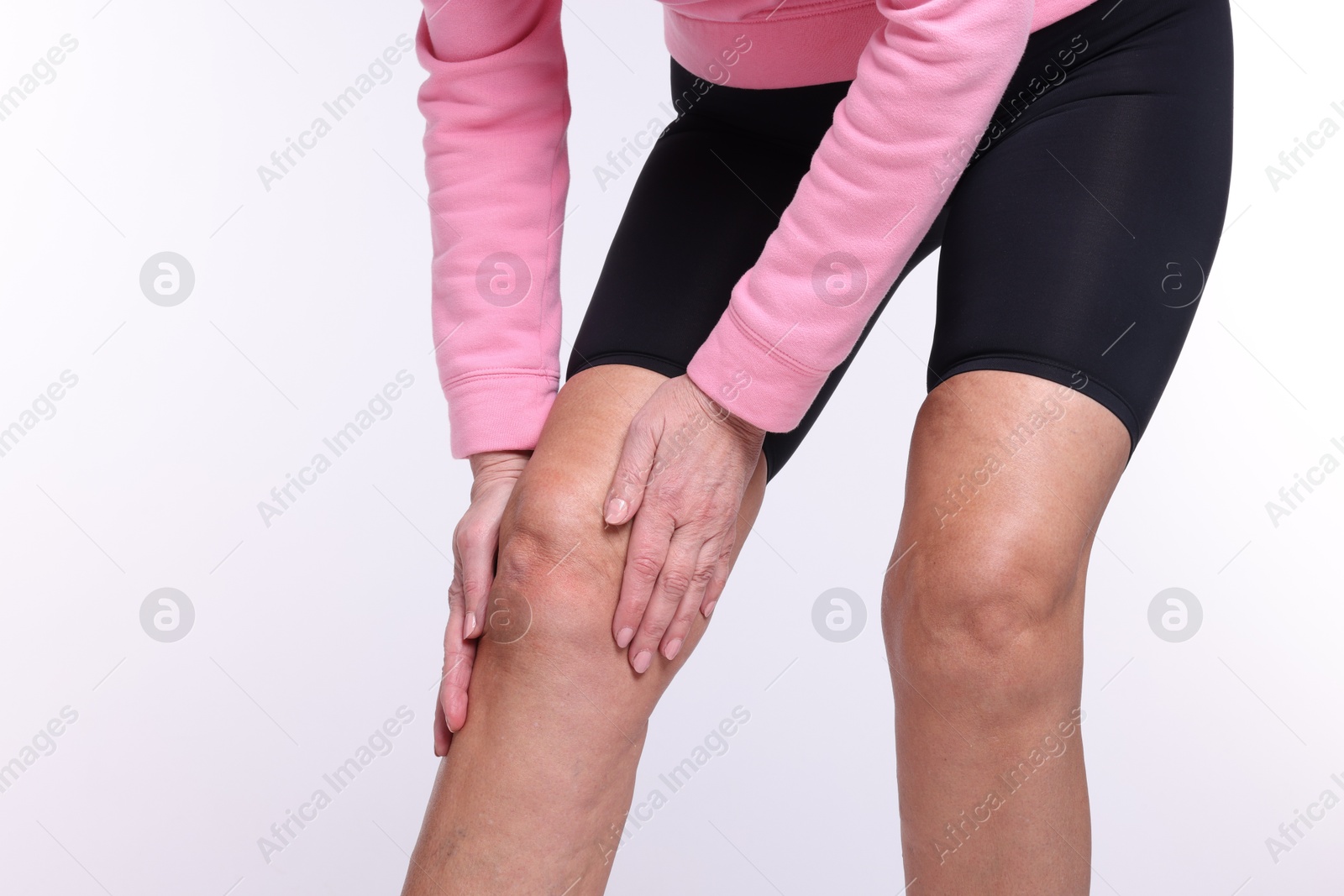 Photo of Woman suffering from pain in her knee on white background, closeup