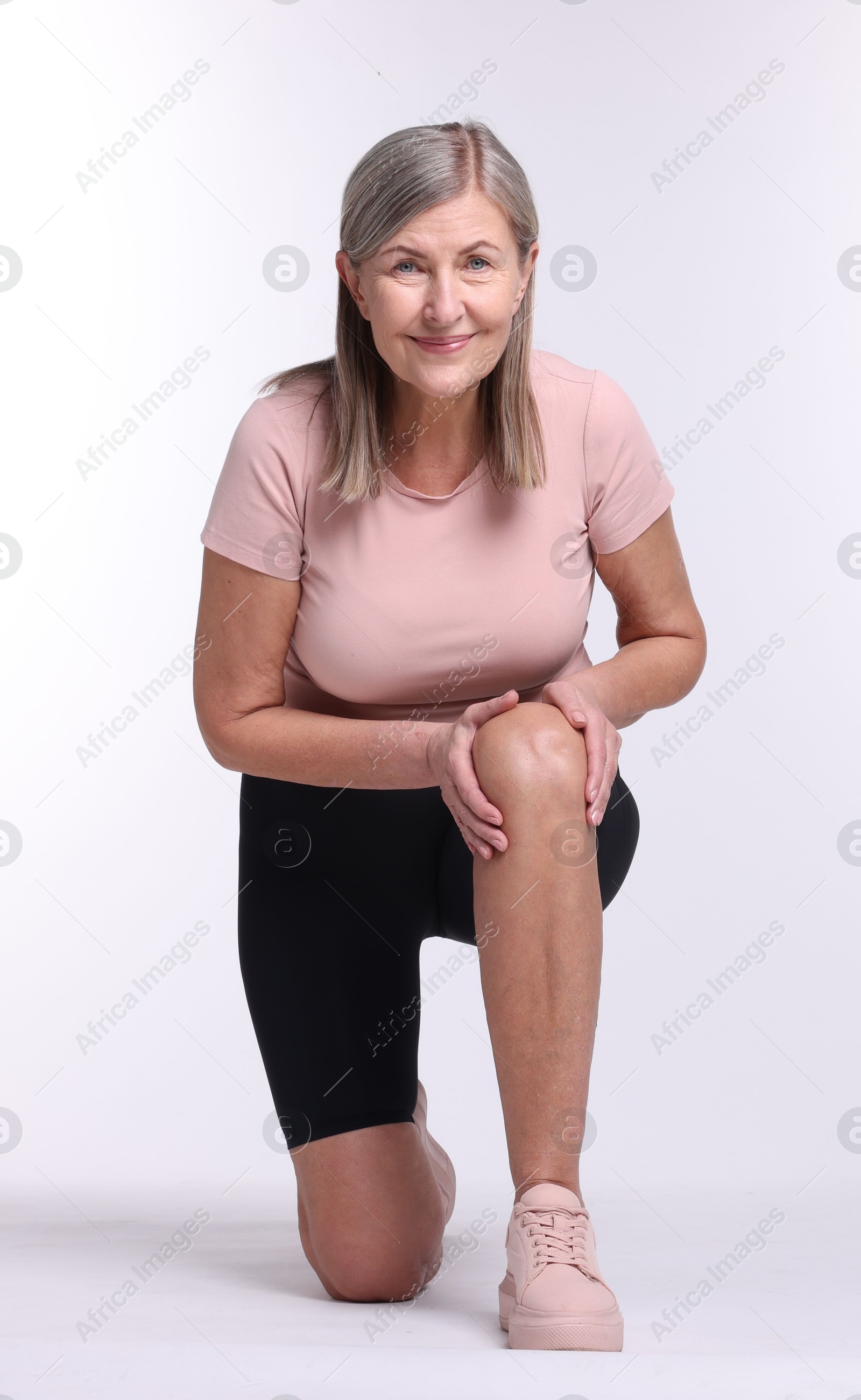 Photo of Senior woman suffering from knee pain on white background