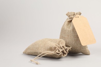 Photo of Two burlap bags on light grey background. Space for text