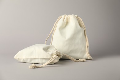 Photo of White cotton bags with ties on light grey background