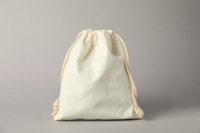 Photo of White cotton bag with ties on light grey background