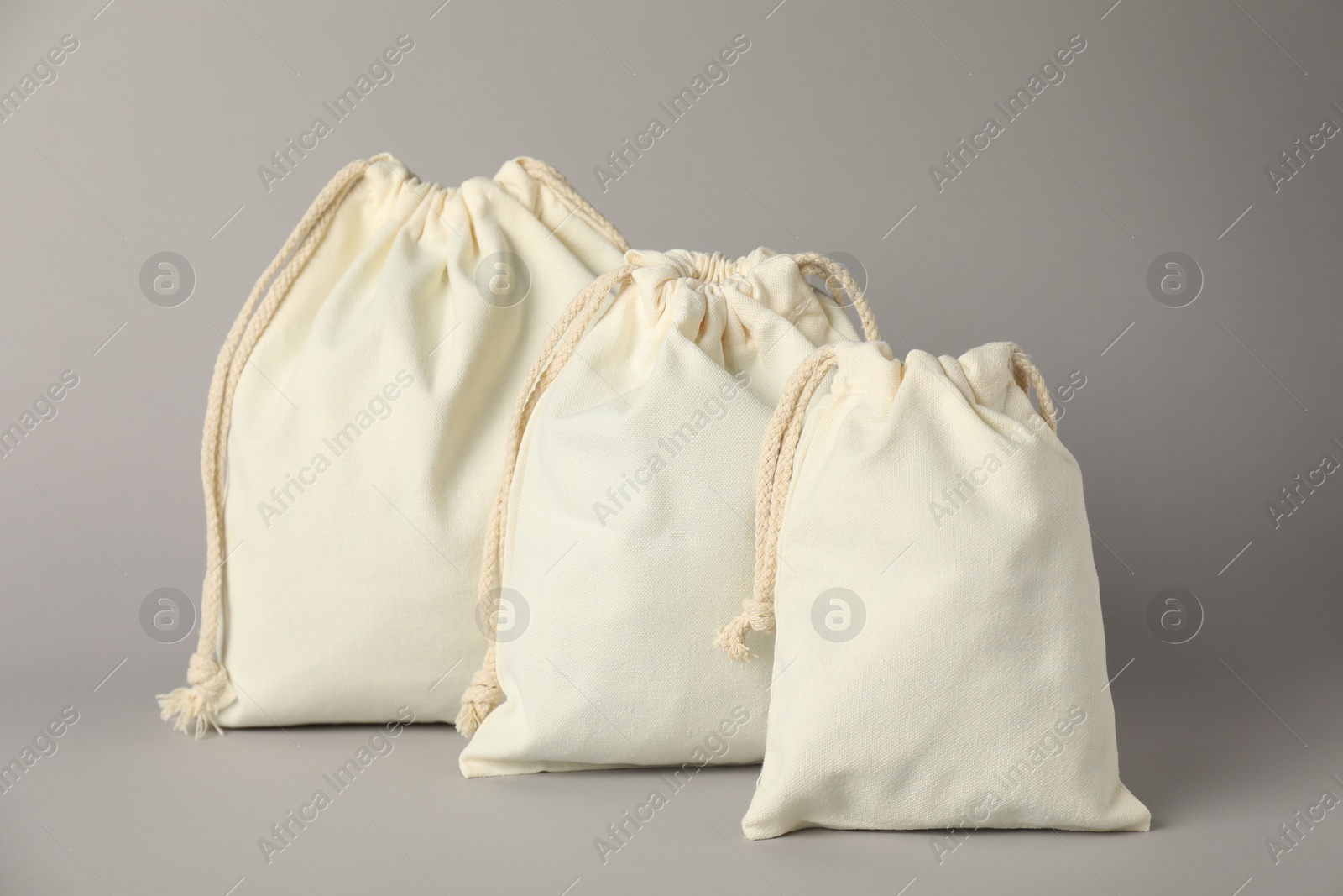 Photo of Cotton bags of different sizes on grey background