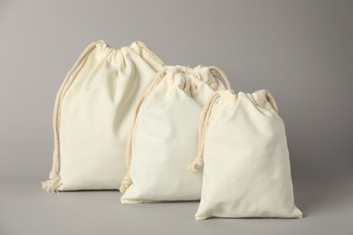 Cotton bags of different sizes on grey background