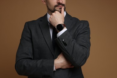 Photo of Man in classic suit on brown background, closeup