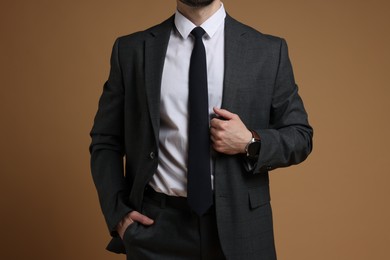 Photo of Man in classic suit on brown background, closeup