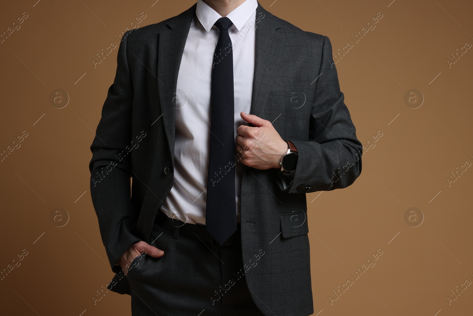 Photo of Man in classic suit on brown background, closeup