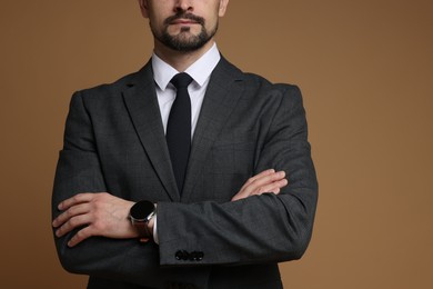 Photo of Man in classic suit with stylish watch on brown background, closeup