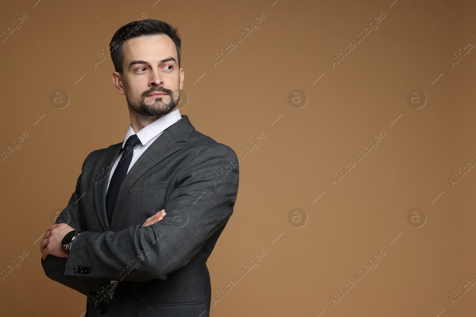 Photo of Handsome man in classic suit on brown background. Space for text