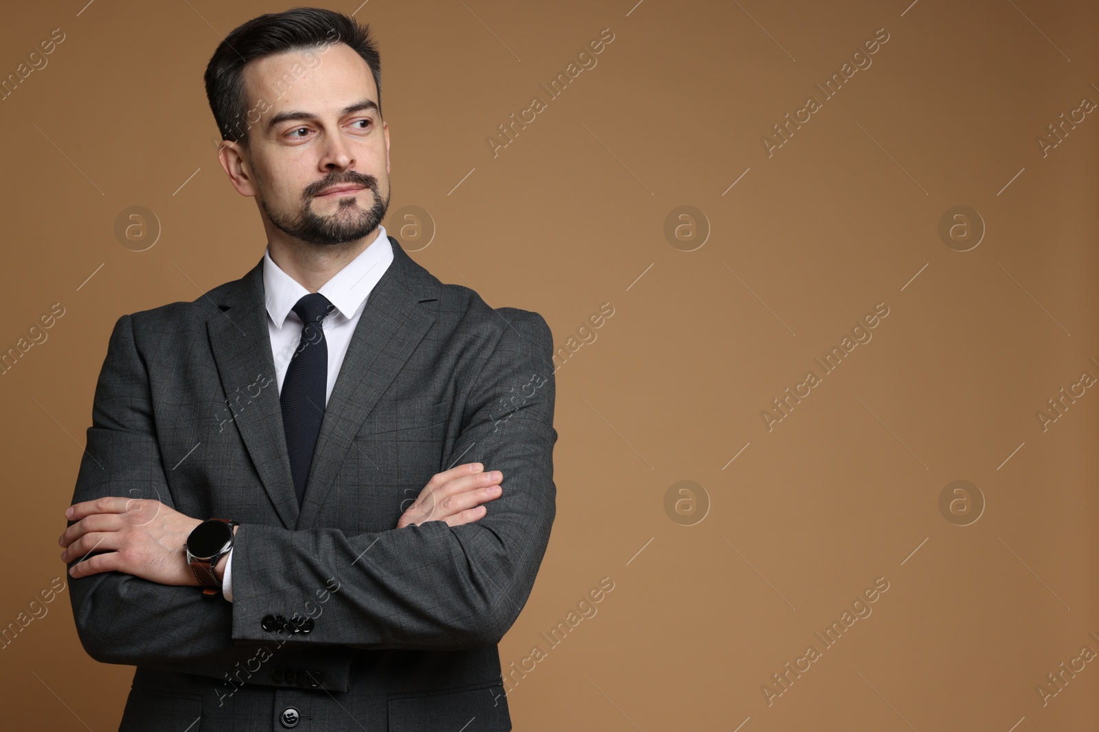 Photo of Handsome man in classic suit on brown background. Space for text