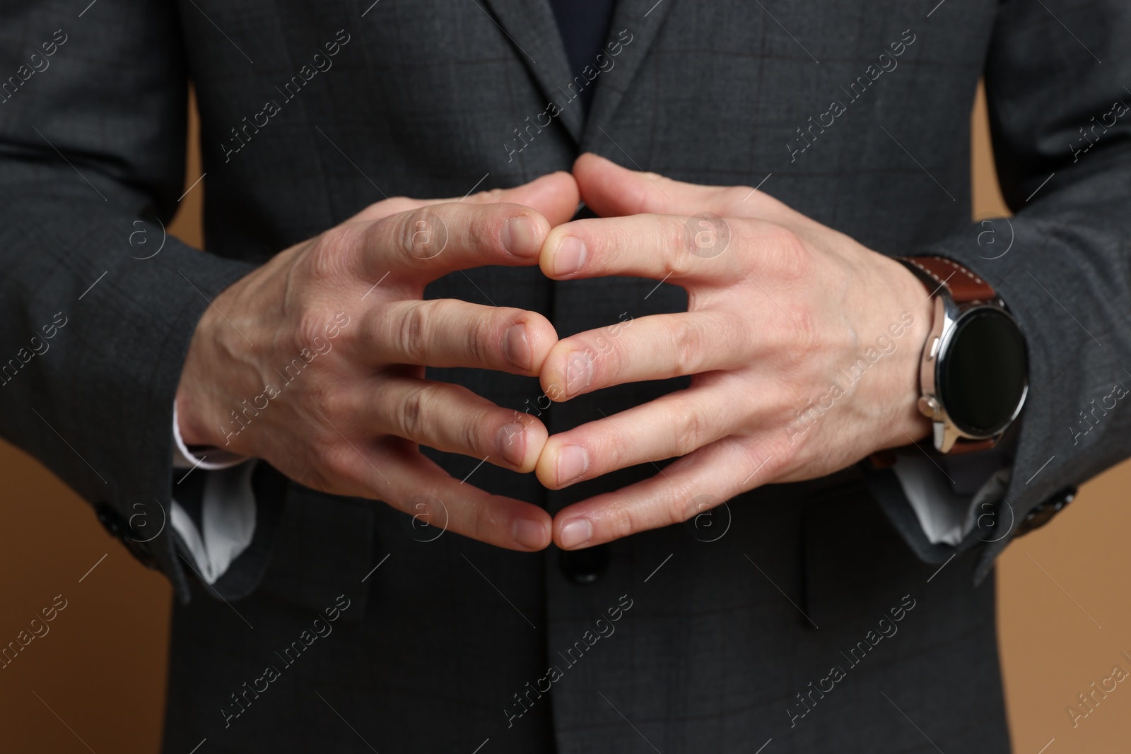 Photo of Man in classic suit on brown background, closeup