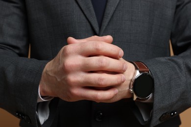 Photo of Man in classic suit on brown background, closeup