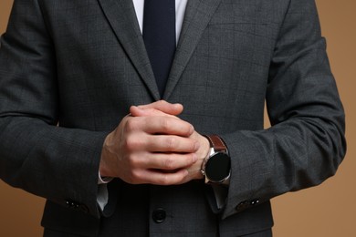 Photo of Man in classic suit on brown background, closeup