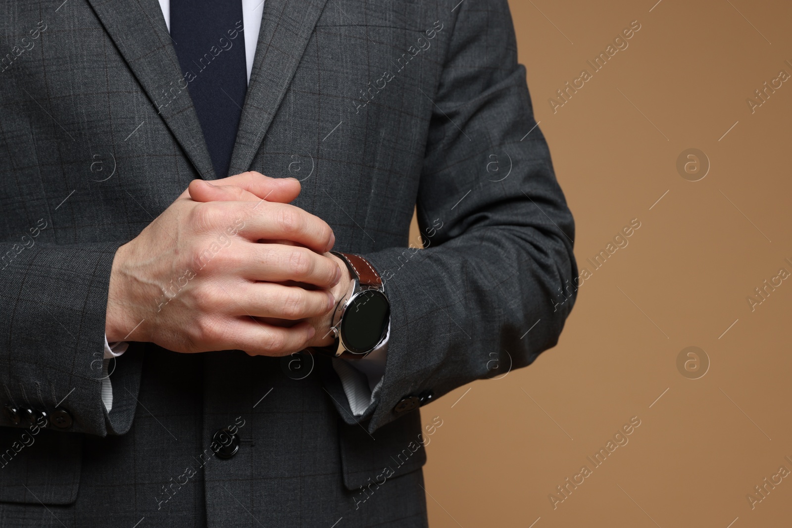 Photo of Man in classic suit on brown background, closeup. Space for text