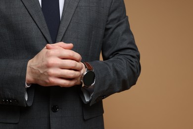 Photo of Man in classic suit on brown background, closeup. Space for text