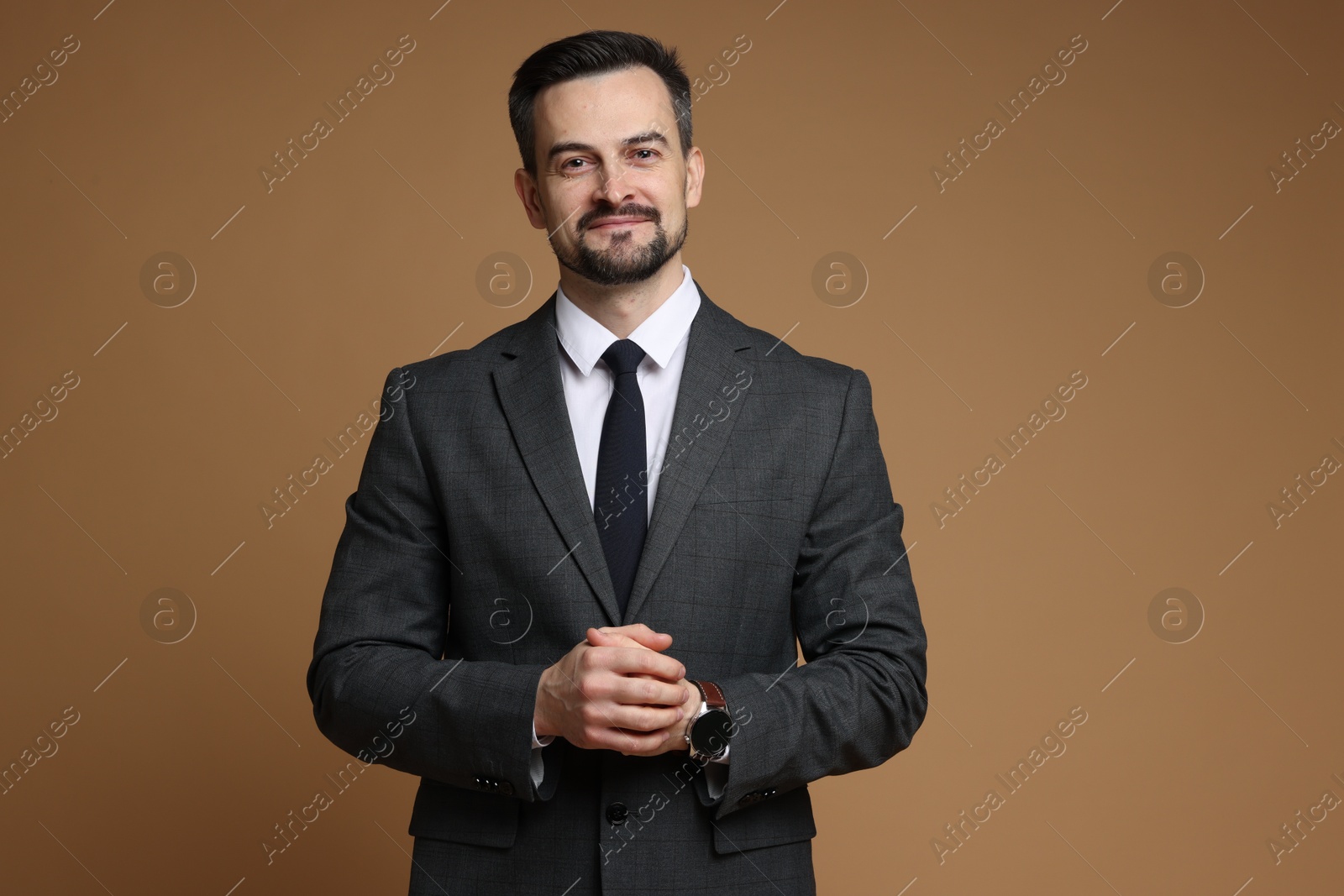 Photo of Handsome man in classic suit on brown background