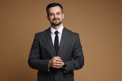 Photo of Handsome man in classic suit on brown background