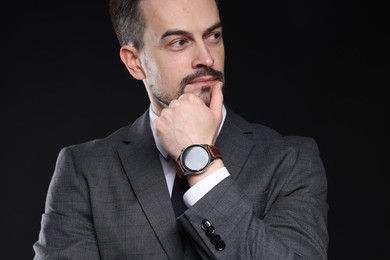 Photo of Confident man in classic suit on black background