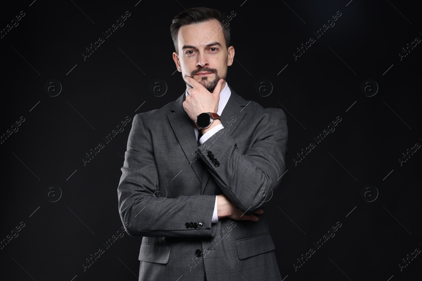 Photo of Confident man in classic suit on black background