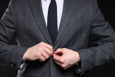 Photo of Man in classic suit on black background, closeup