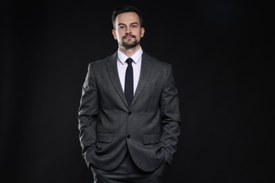 Photo of Confident man in classic suit on black background