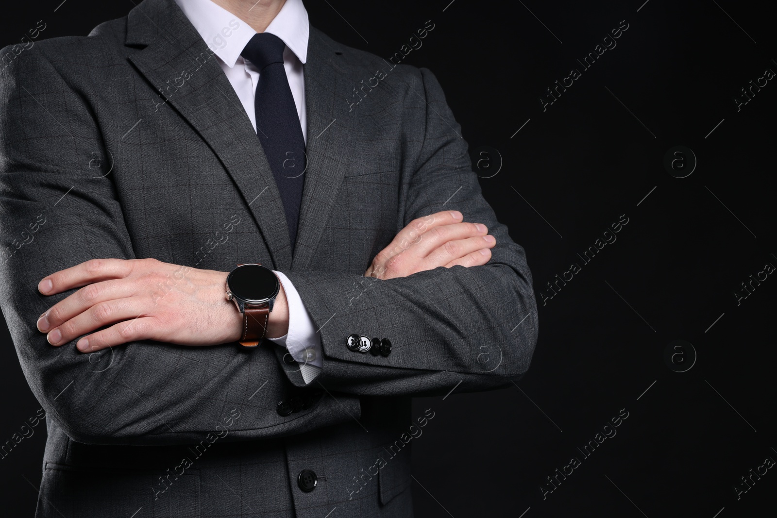 Photo of Man in classic suit with stylish watch on black background, closeup. Space for text