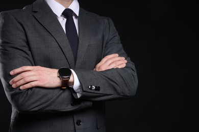 Photo of Man in classic suit with stylish watch on black background, closeup. Space for text