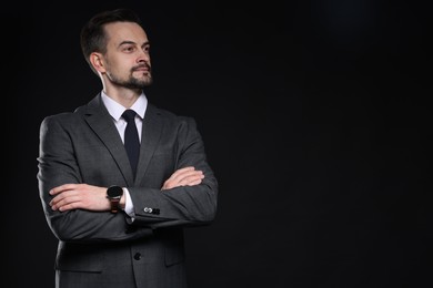 Photo of Confident man in classic suit on black background. Space for text