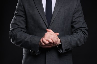 Photo of Man in classic suit on black background, closeup