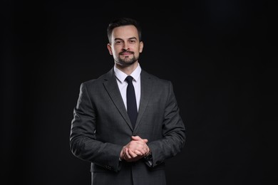 Photo of Confident man in classic suit on black background