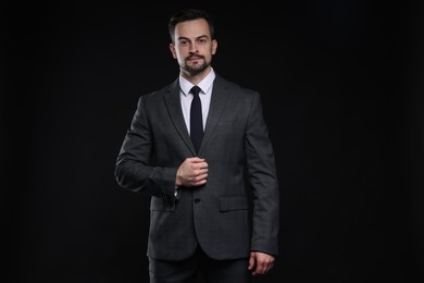 Photo of Confident man in classic suit on black background