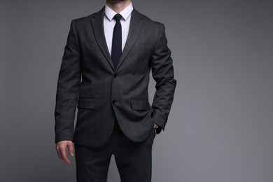 Photo of Man in classic suit on grey background, closeup