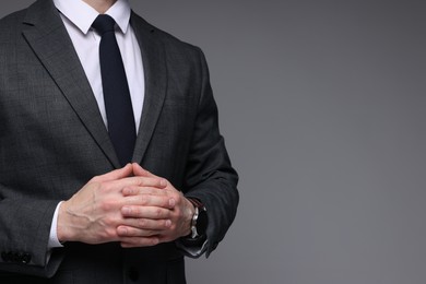 Photo of Man in classic suit on grey background, closeup. Space for text