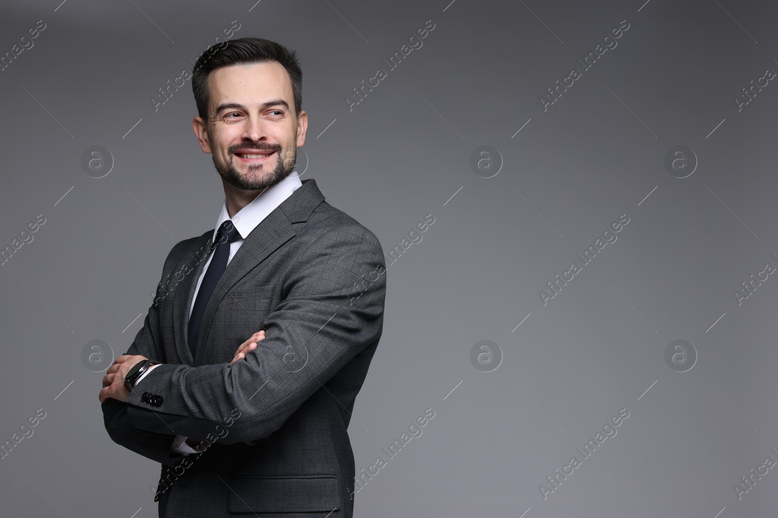 Photo of Handsome man in classic suit on grey background. Space for text