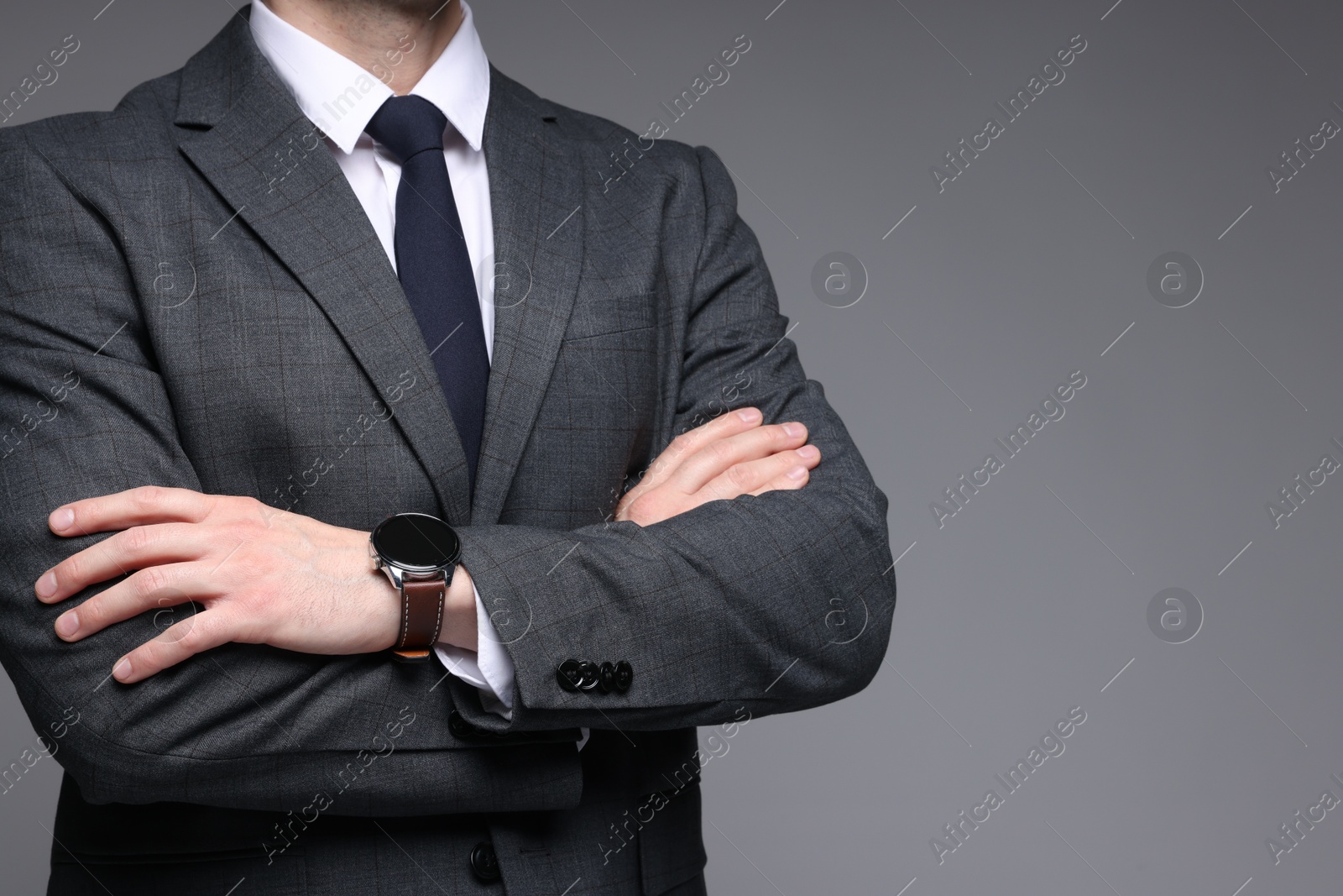 Photo of Man in classic suit on grey background, closeup. Space for text