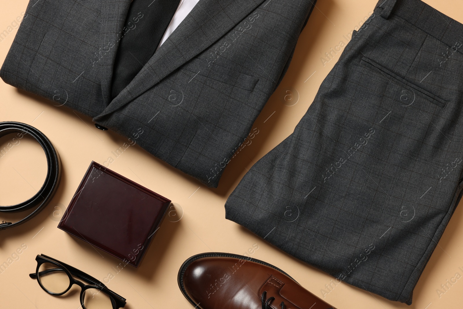 Photo of Elegant men's outfit. Stylish suit, accessories and shoes on beige background, flat lay