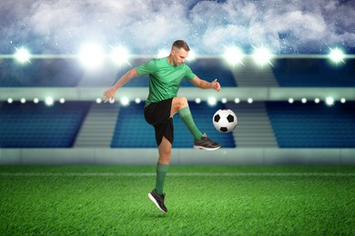 Image of Young man playing football under lights at stadium