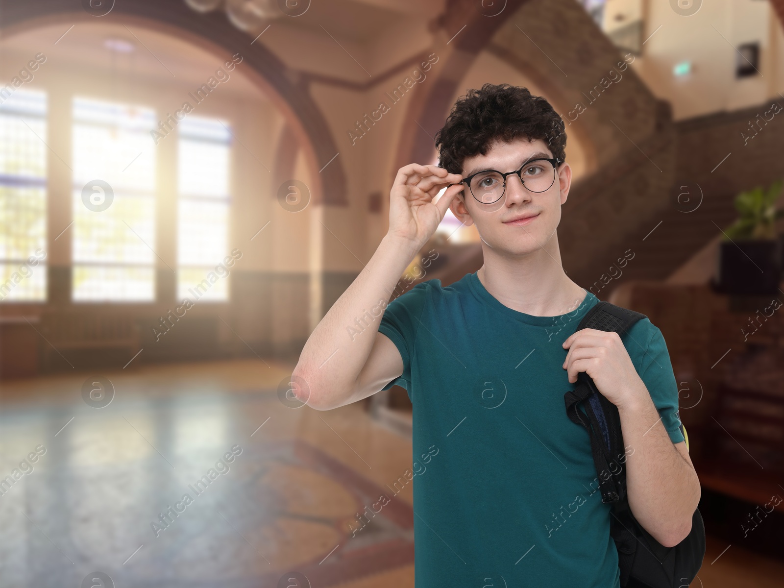 Image of Teenage student with eyeglasses and backpack in college