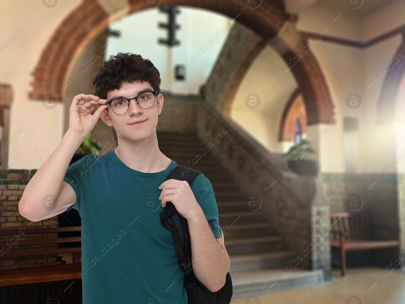 Image of Teenage student with eyeglasses and backpack in college