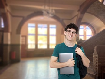 Image of Teenage student with eyeglasses, laptop and backpack in college