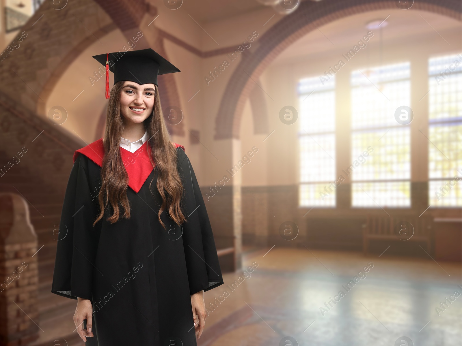 Image of Happy student wearing academic dress during graduation in university