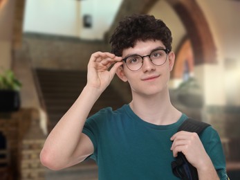 Image of Teenage student with eyeglasses and backpack in college